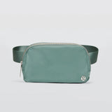 A greyish turquoise Lululemon Everywhere Belt Bag 1L with a zipper closure and an adjustable strap, displayed against a white background.